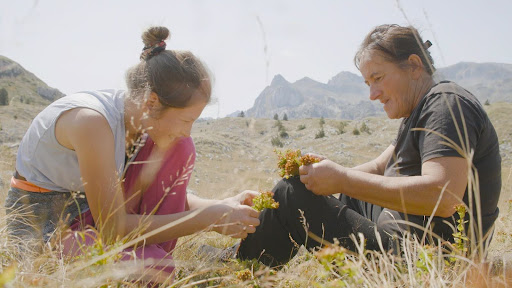 (left to right) Nada and Gara creating a flower wreath in the highlands of Sinjajevina in “To Hold a Mountain” (Courtesy of Sundance Institute)